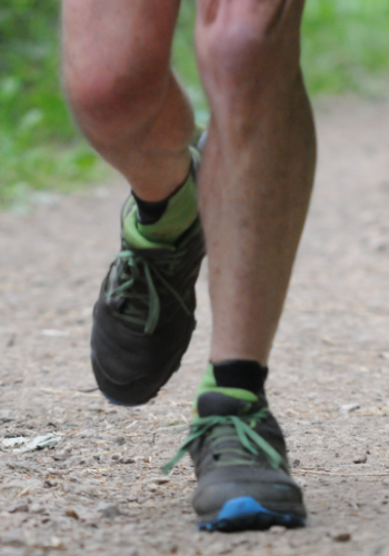 Photo of a runner's feet and lower legs as they run uphill.